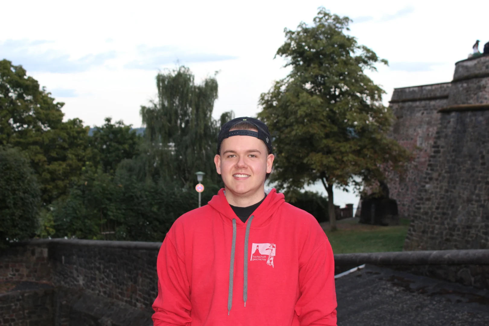 Eine Wissenschaftlerin und ein Wissenschaftler arbeiten hinter einer Glasfassade und mischen Chemikalien mit Großgeräten.