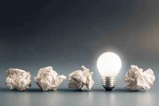 Eine Wissenschaftlerin und ein Wissenschaftler arbeiten hinter einer Glasfassade und mischen Chemikalien mit Großgeräten.