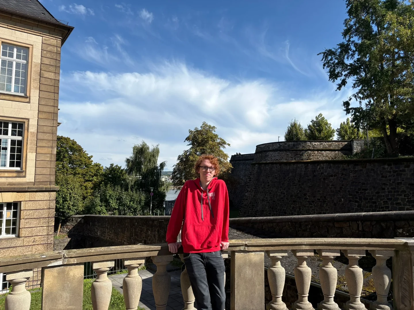 Eine Wissenschaftlerin und ein Wissenschaftler arbeiten hinter einer Glasfassade und mischen Chemikalien mit Großgeräten.