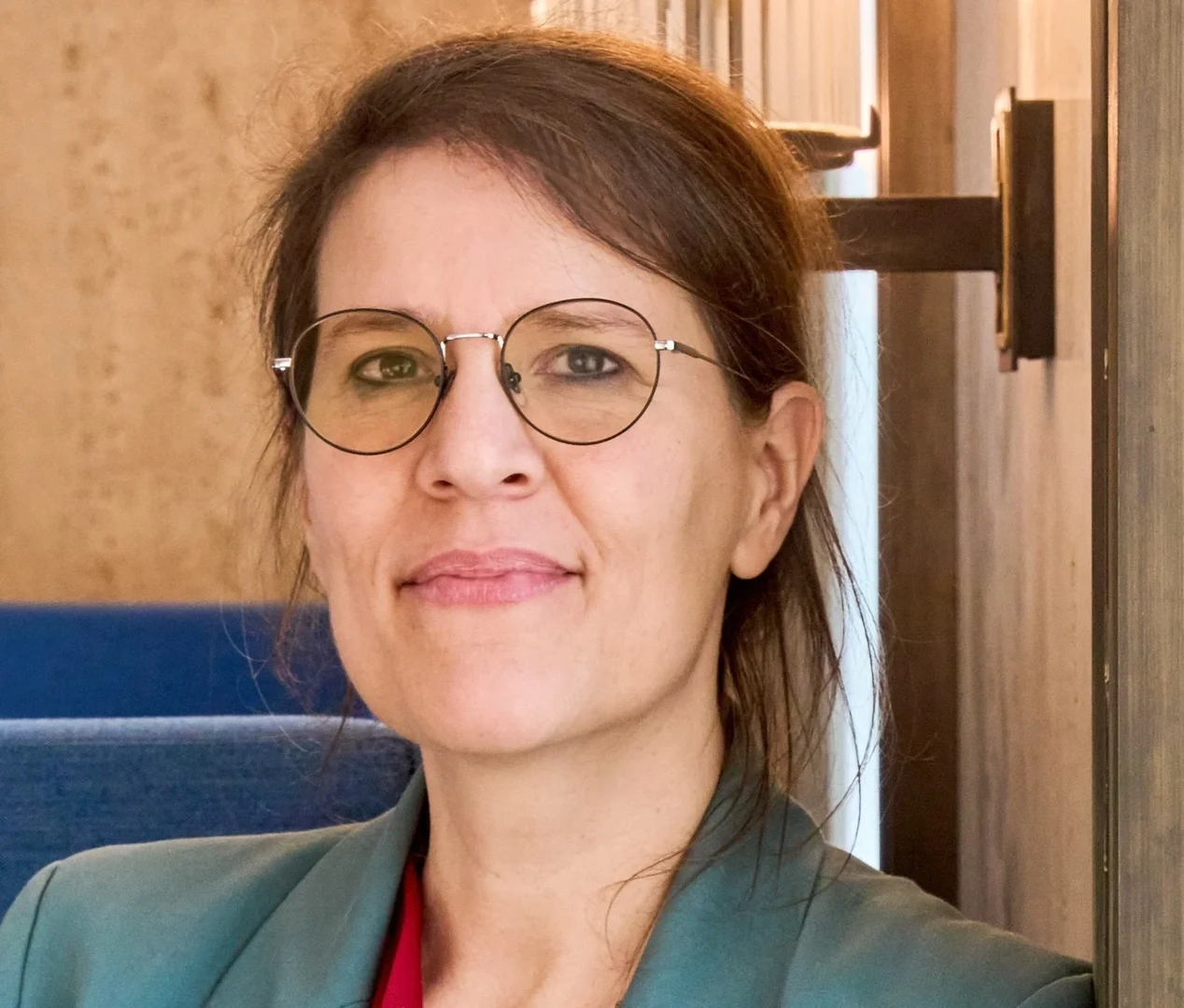 Eine Wissenschaftlerin und ein Wissenschaftler arbeiten hinter einer Glasfassade und mischen Chemikalien mit Großgeräten.