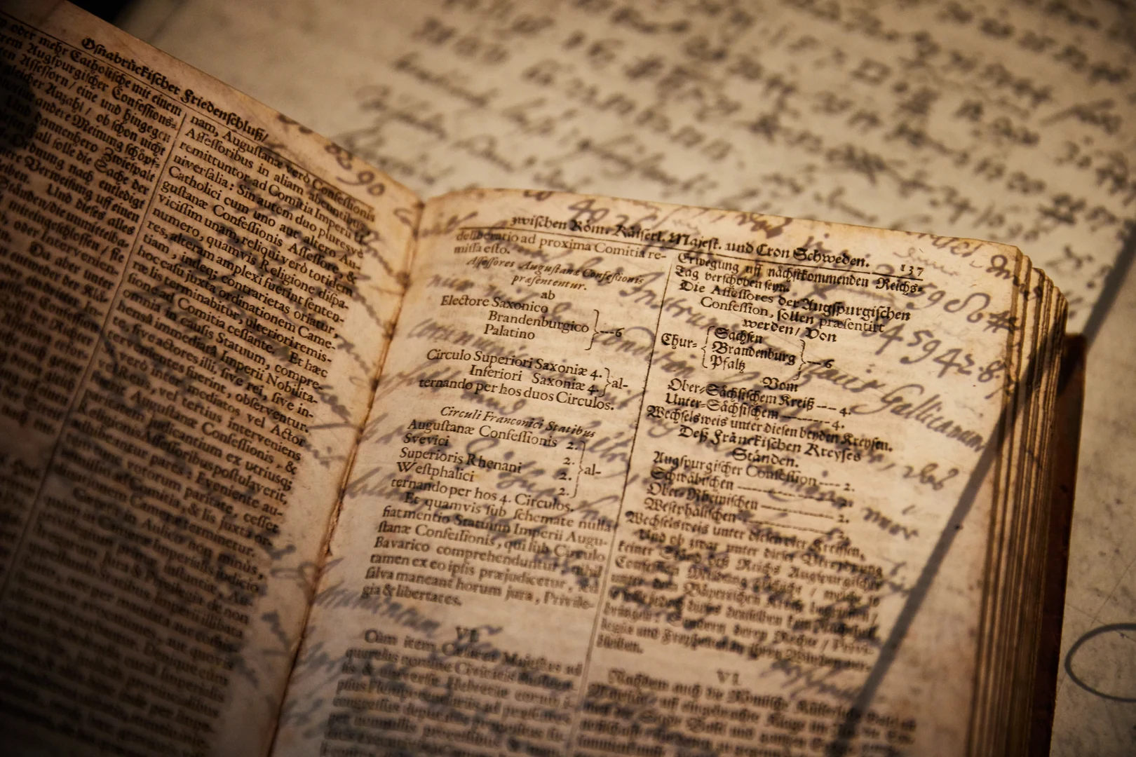 Eine Wissenschaftlerin und ein Wissenschaftler arbeiten hinter einer Glasfassade und mischen Chemikalien mit Großgeräten.